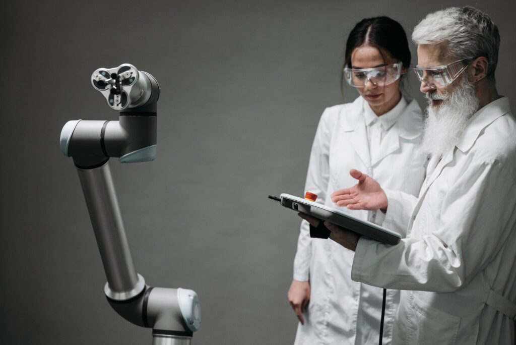 Vedec a študentka pracujú s robotickým ramenom a AI technológiami počas štúdia